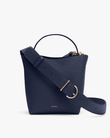 Small handbag with a wide strap and top handle.