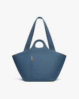 Large tote bag with short handles, long straps, and a front zipper pocket.