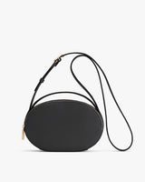 Round purse with a long strap and zipper on a white background