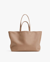 Large leather tote bag with two handles, standing upright.