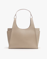 Handbag with two external pockets and a single handle.