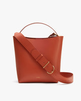 Bucket bag with a wide strap and top handle.