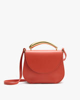 A handbag with a curved flap, a top handle, and a shoulder strap.