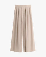 Wide-leg pants with pleats on a plain background.