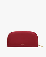 Half-moon shaped leather clutch with zipper and subtle branding in the center.