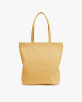 Tote bag with long handles on plain background.