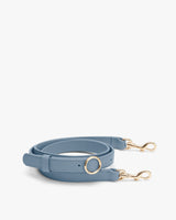 Adjustable bag strap with gold clasps on both ends.