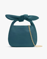 Handbag with a knotted handle and a chain strap.