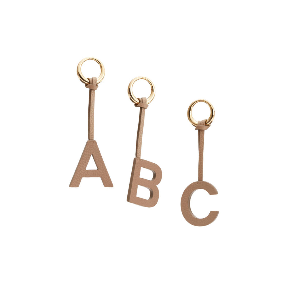 Three keychains with letters A, B, and C attached to rings.