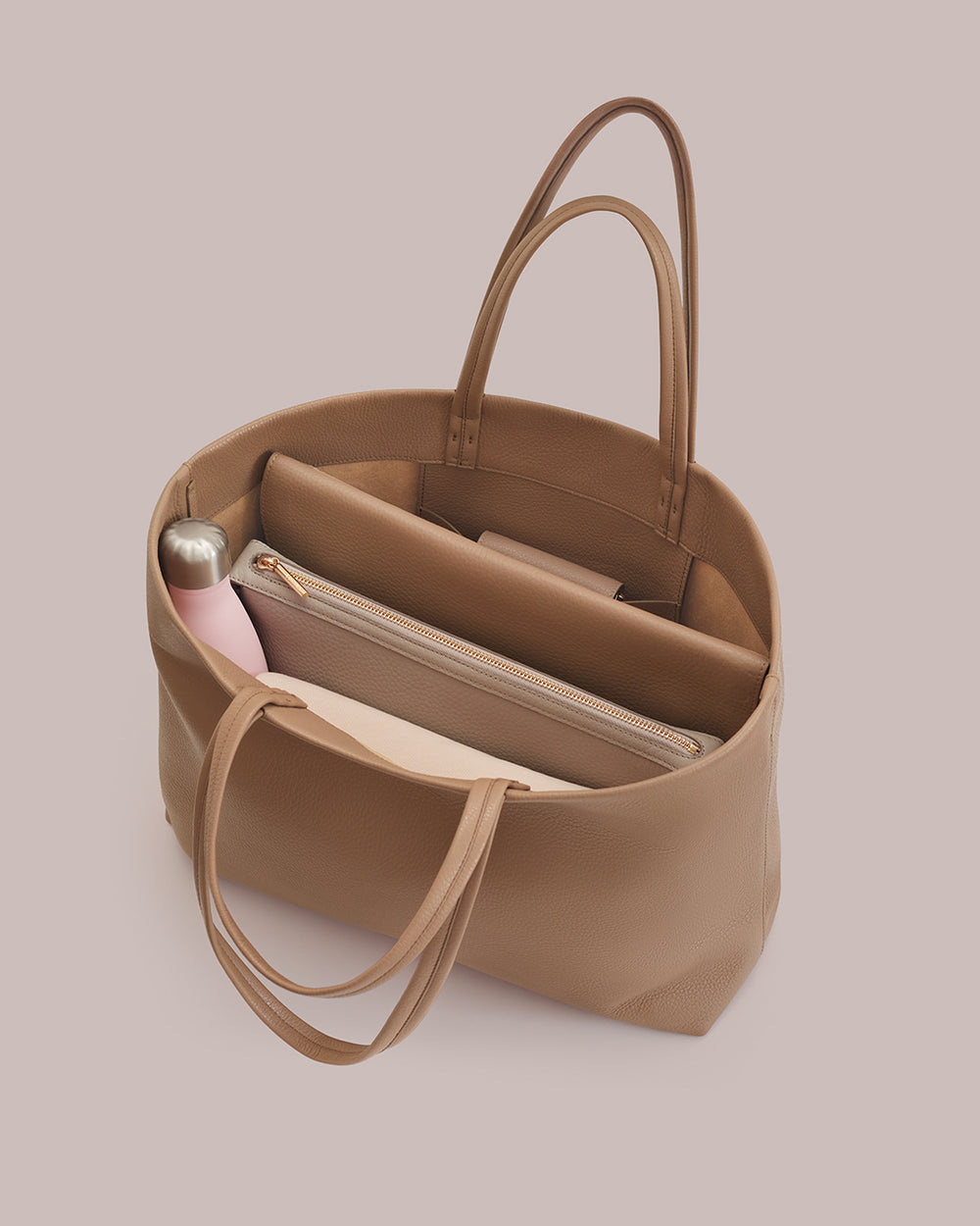Open tote bag with a water bottle, laptop, and pouches inside