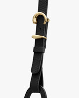 Close-up of a strap with gold metal buckle and textured leather detail