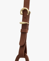 Close-up of a textured leather strap with metal buckle detail
