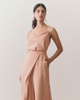 Person in a sleeveless top with thin straps and wide leg pants