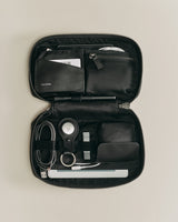 Organizer case with various personal items and tech accessories.