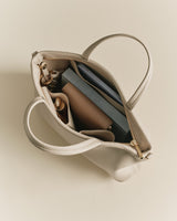 Open handbag with visible contents including a wallet and keys.