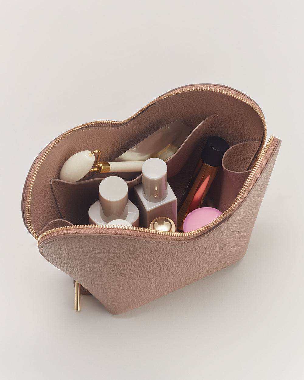 Heart Case Open cosmetic bag filled with various makeup products.