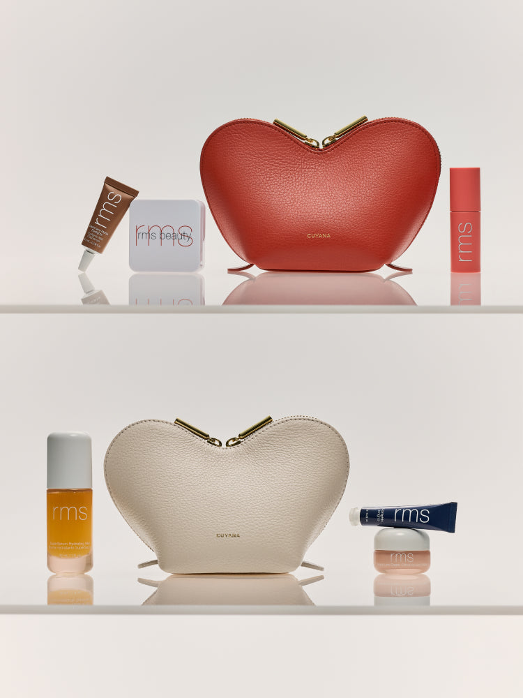 Two heart-shaped zipper pouches with cosmetics arranged around them on a shelf.