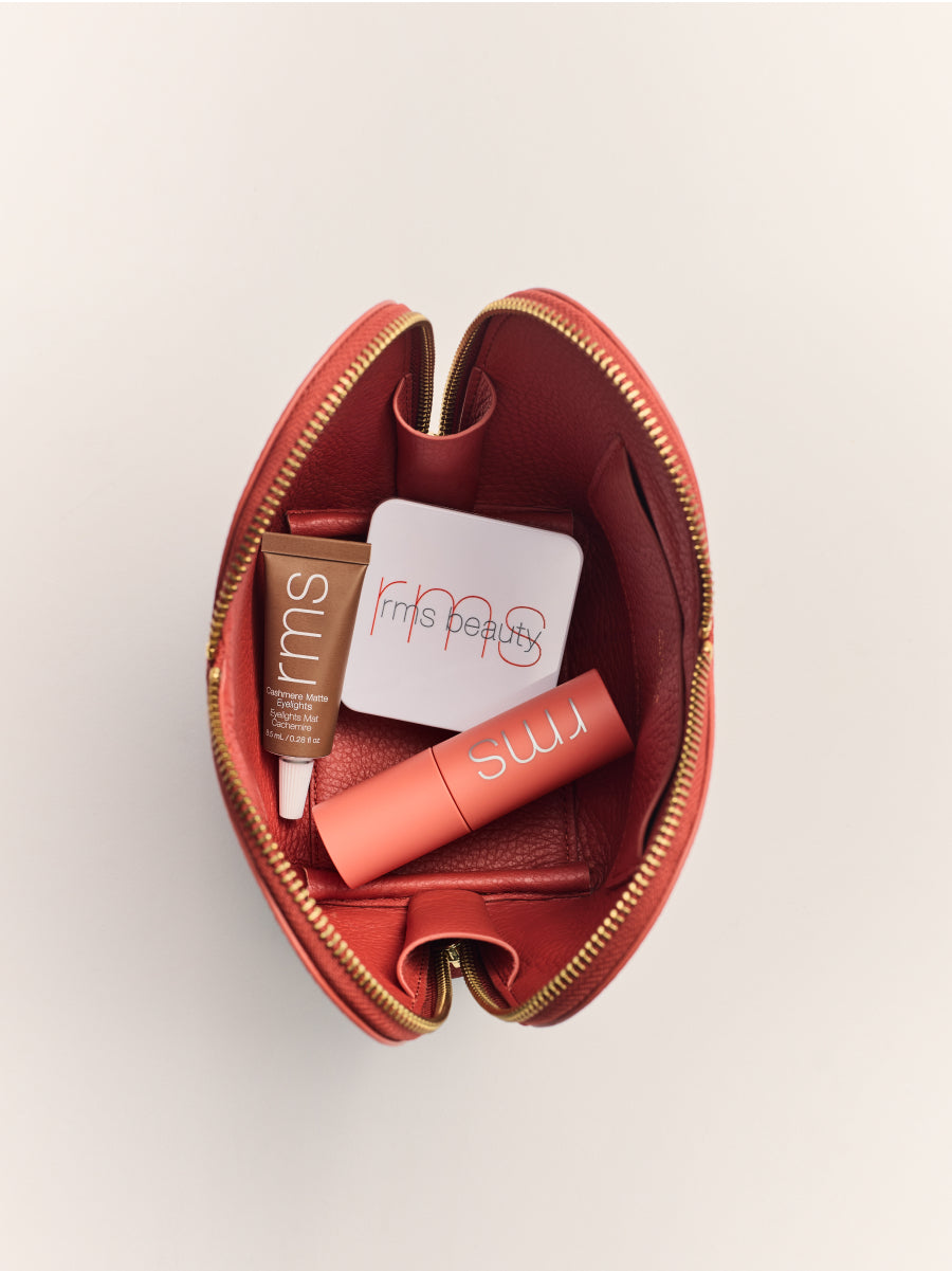 Makeup items inside an open pouch.