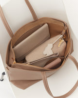 Open handbag containing a wallet, a pouch, and keys.