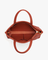 Open handbag with two handles and a zippered compartment inside.
