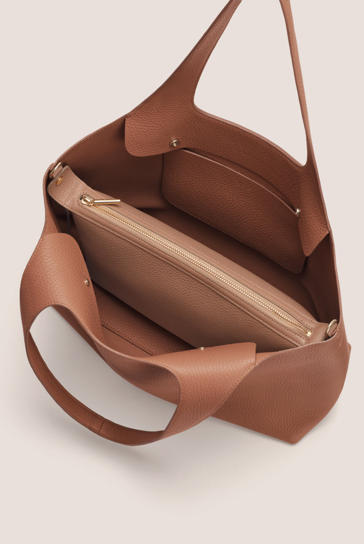 Open handbag with interior pockets and zippers visible.