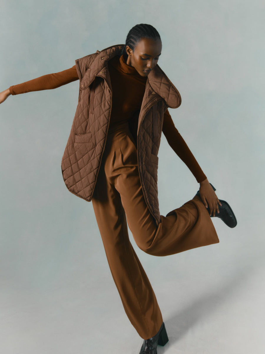 Person in an expressive dance pose with one leg lifted.