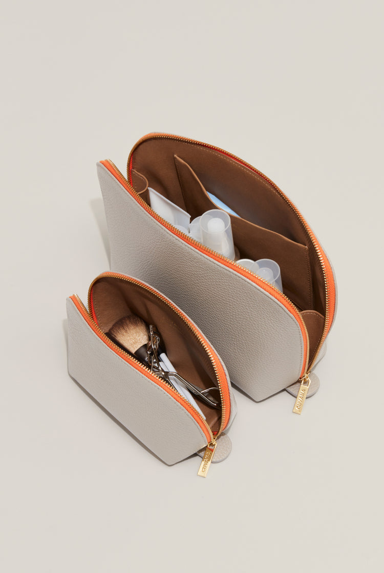 Two open cosmetic bags with various items inside.