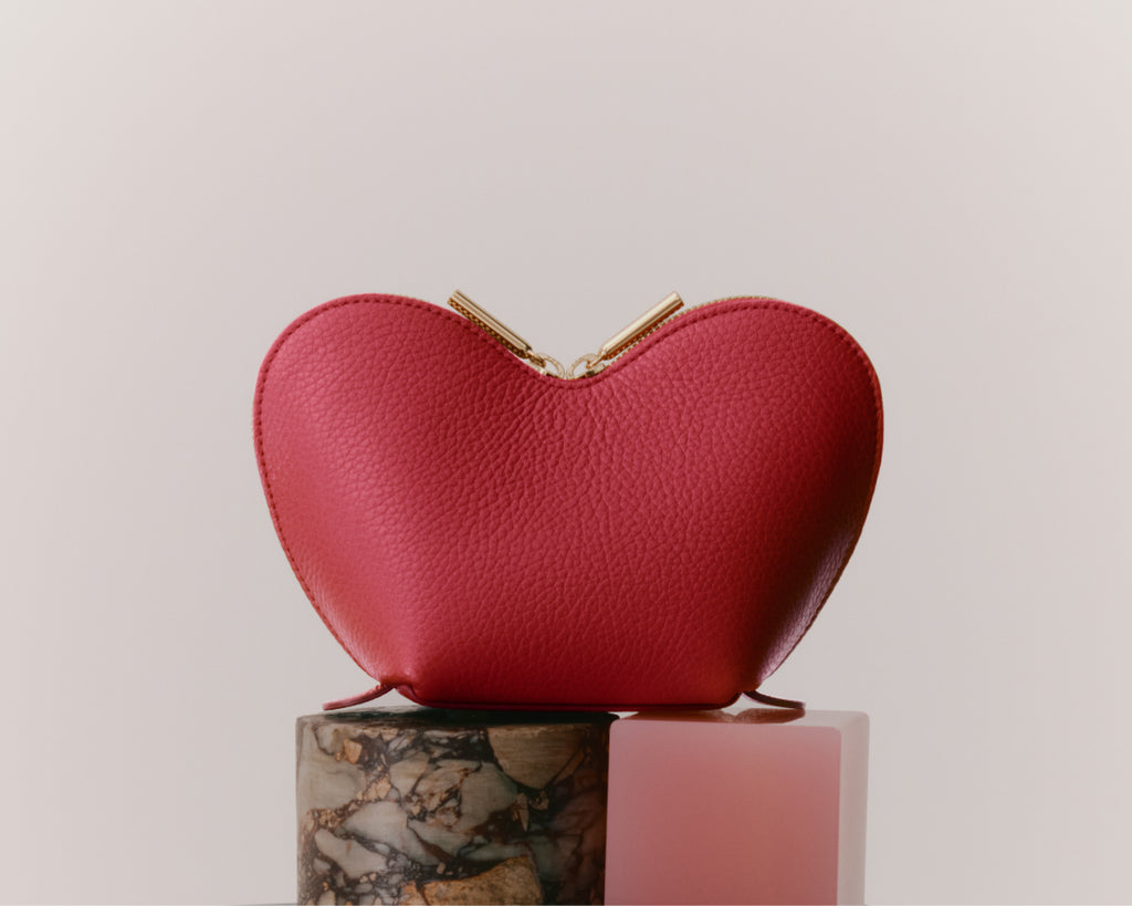 Heart-shaped purse on a cylindrical base.