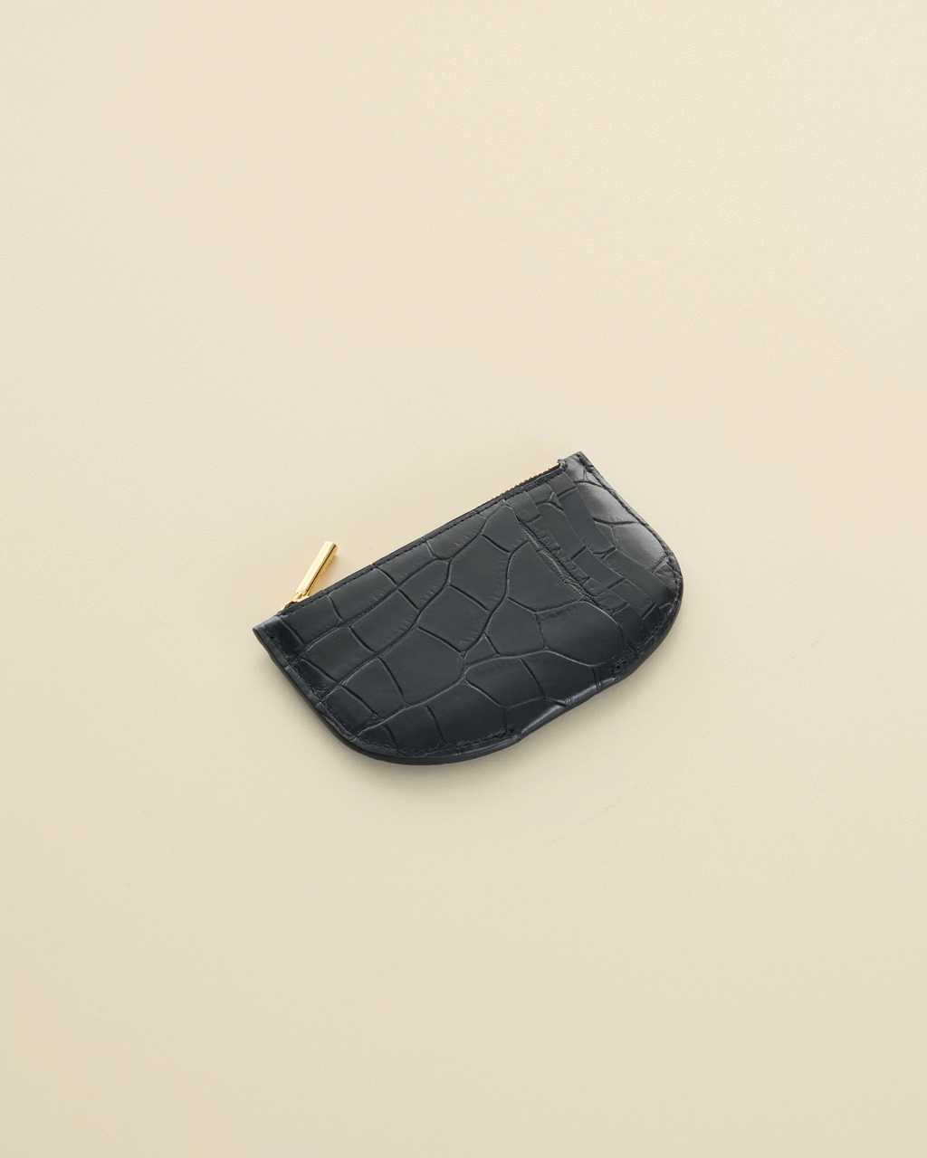 a curved cardholder made of croc embossed leather on the side.