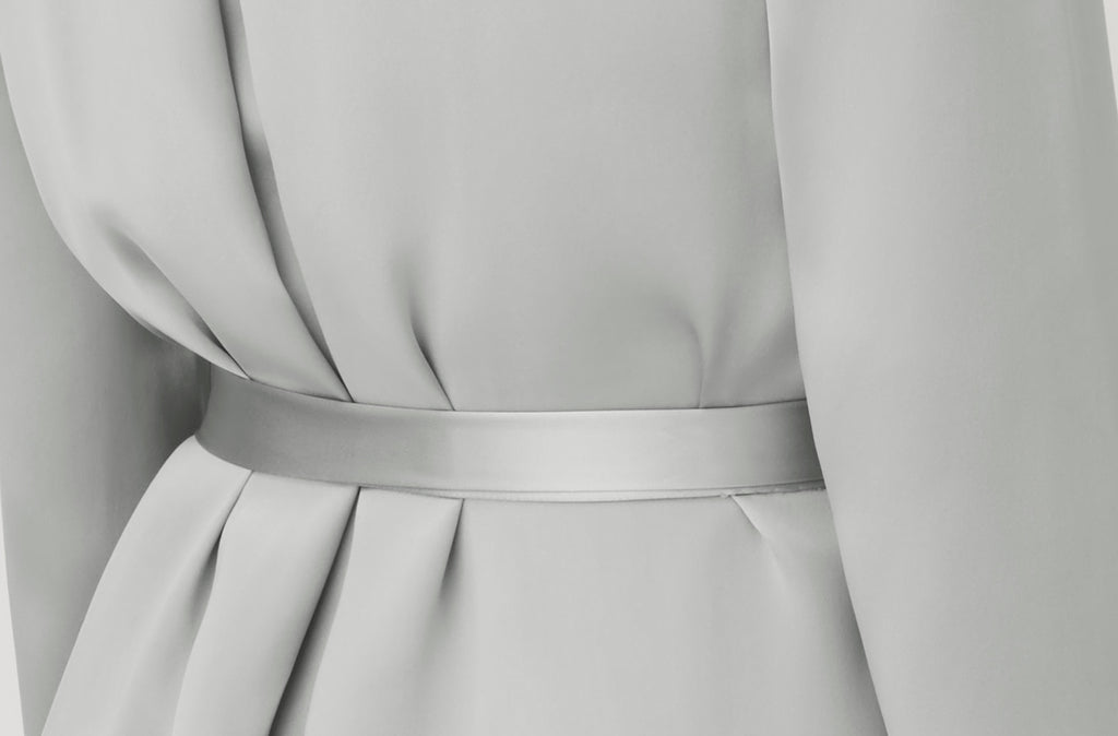 Close-up of a dress with a fitted waistband and pleated detail.