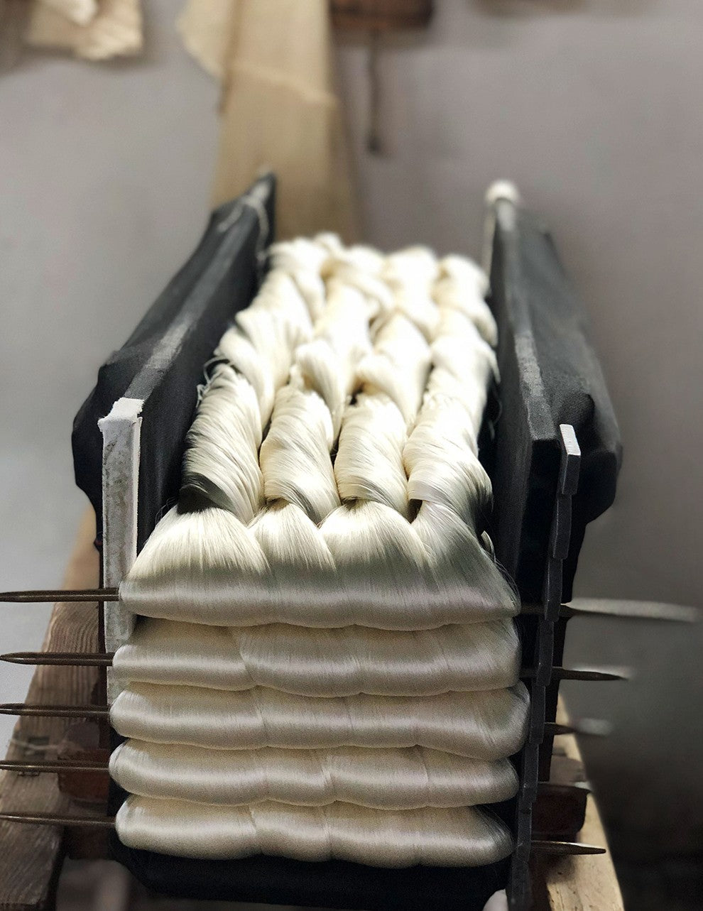 Yarn spools stacked on a textile machine.