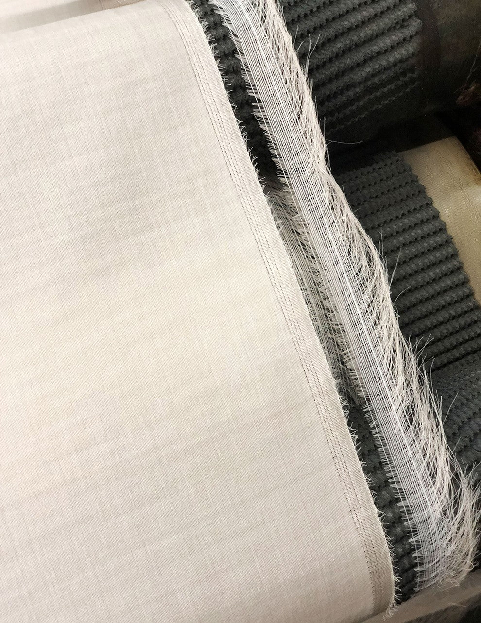 Rolled fabrics with frayed edges on display