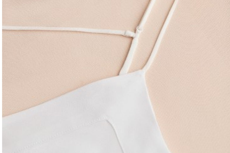 Close-up of a garment with thin straps on a smooth surface