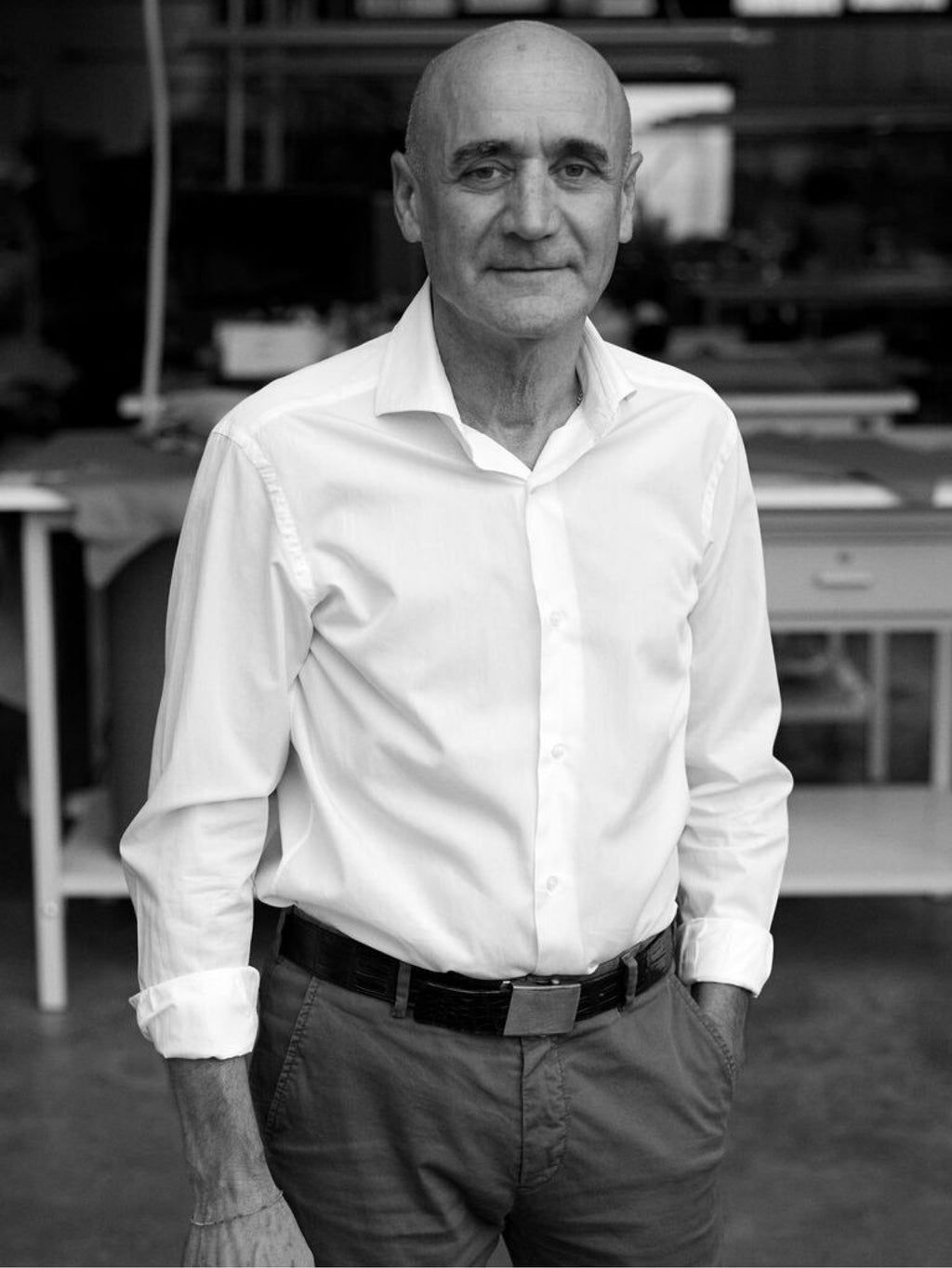 Man standing in a workshop with hands in pockets.