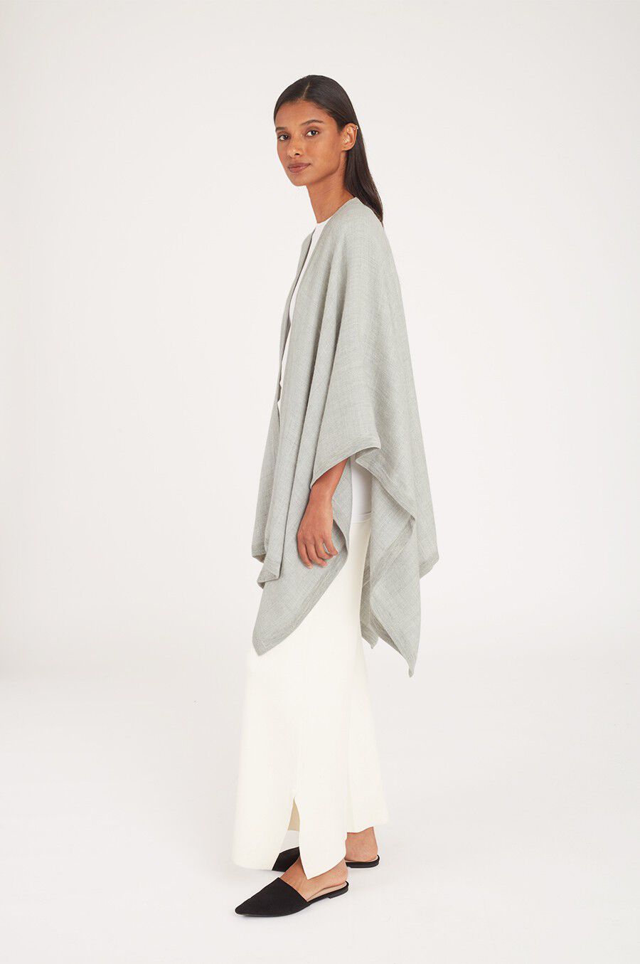 Baby Alpaca Square Edge Cape Woman wearing a draped top and wide-leg pants, posing in a studio.