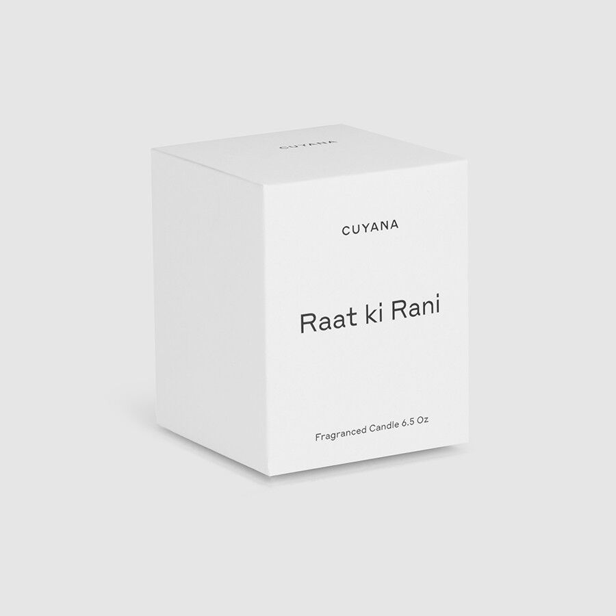 Candle in a labeled box on a plain background