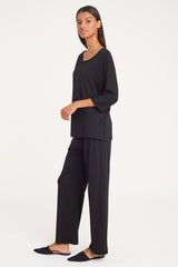 Woman standing in relaxed outfit with a neutral background