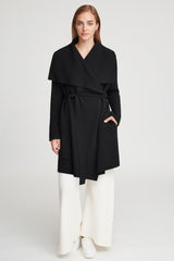 Woman standing in a belted top and wide-leg pants