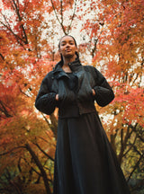 Woman standing outdoors with trees in the background