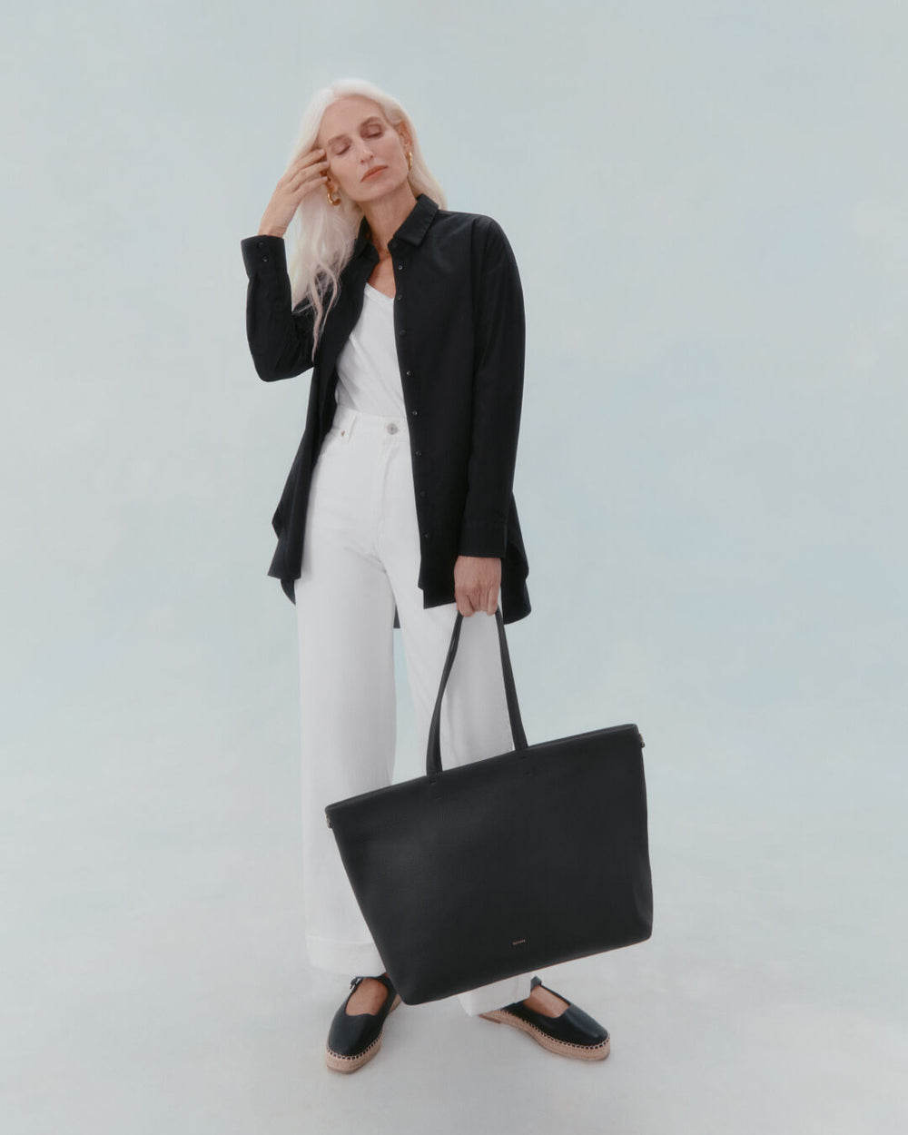 Classic Easy Zipper Tote Woman standing with a hand on her forehead, holding a large bag.