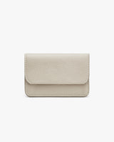Small textured wallet with flap closure on a plain background