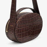 Round-shaped bag with textured pattern and zipper closure.