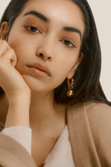 Close-up of a woman resting her cheek on her hand.