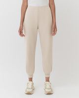 Person in sneakers and pants, cropped to show only the lower half.