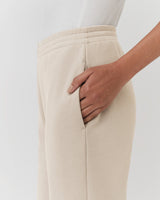 Person standing with hand in pocket of their skirt.