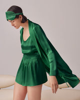 Woman in a coordinated outfit and headband leaning on a couch.