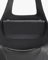 Close-up view of the top part of a handbag with a handle.