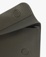 Close-up of a textured wallet with a flap closure and visible snap buttons.