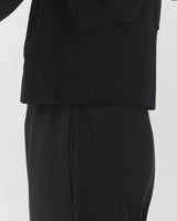 Person wearing a formal top and trousers.