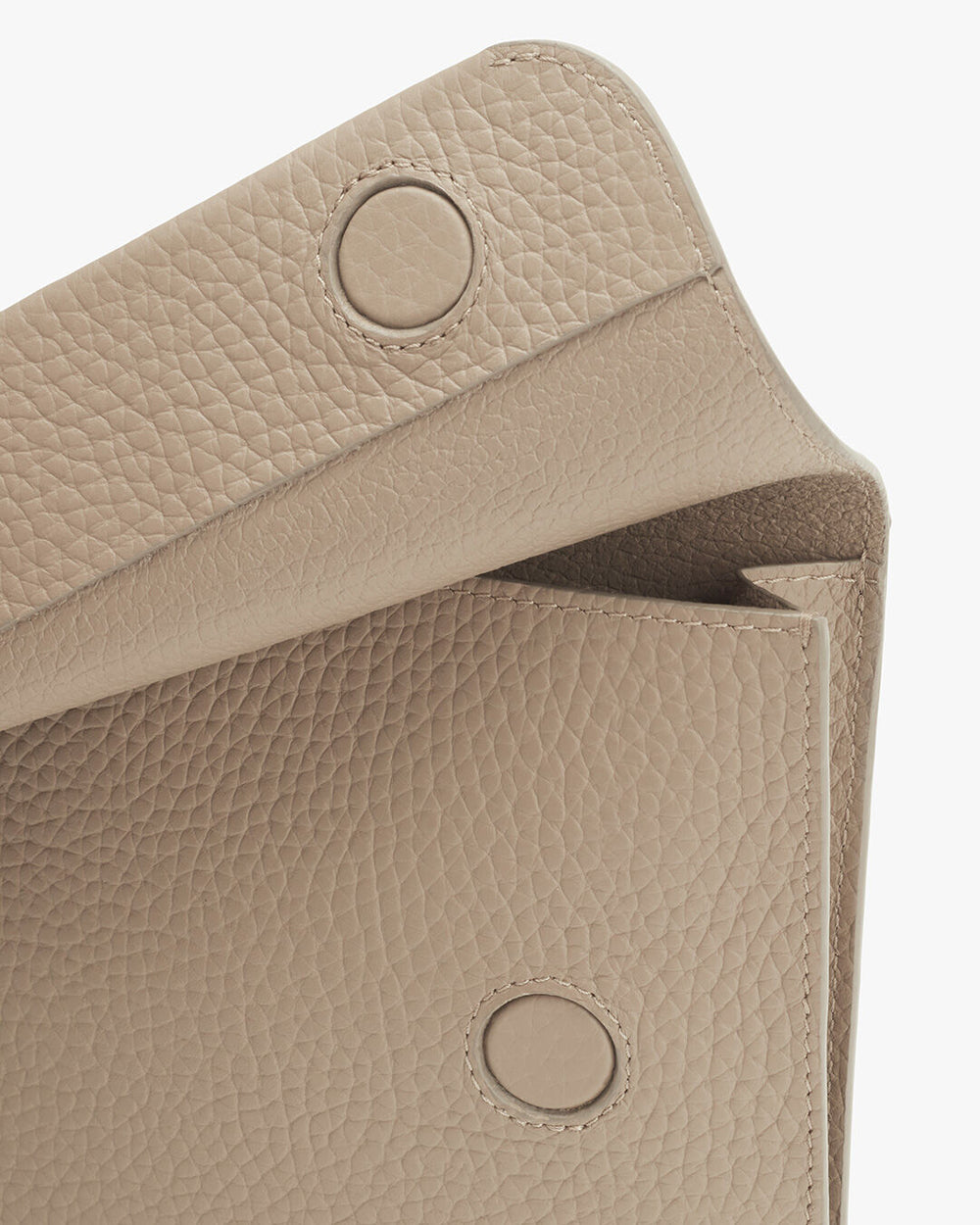 Close-up view of a textured purse with flap open.